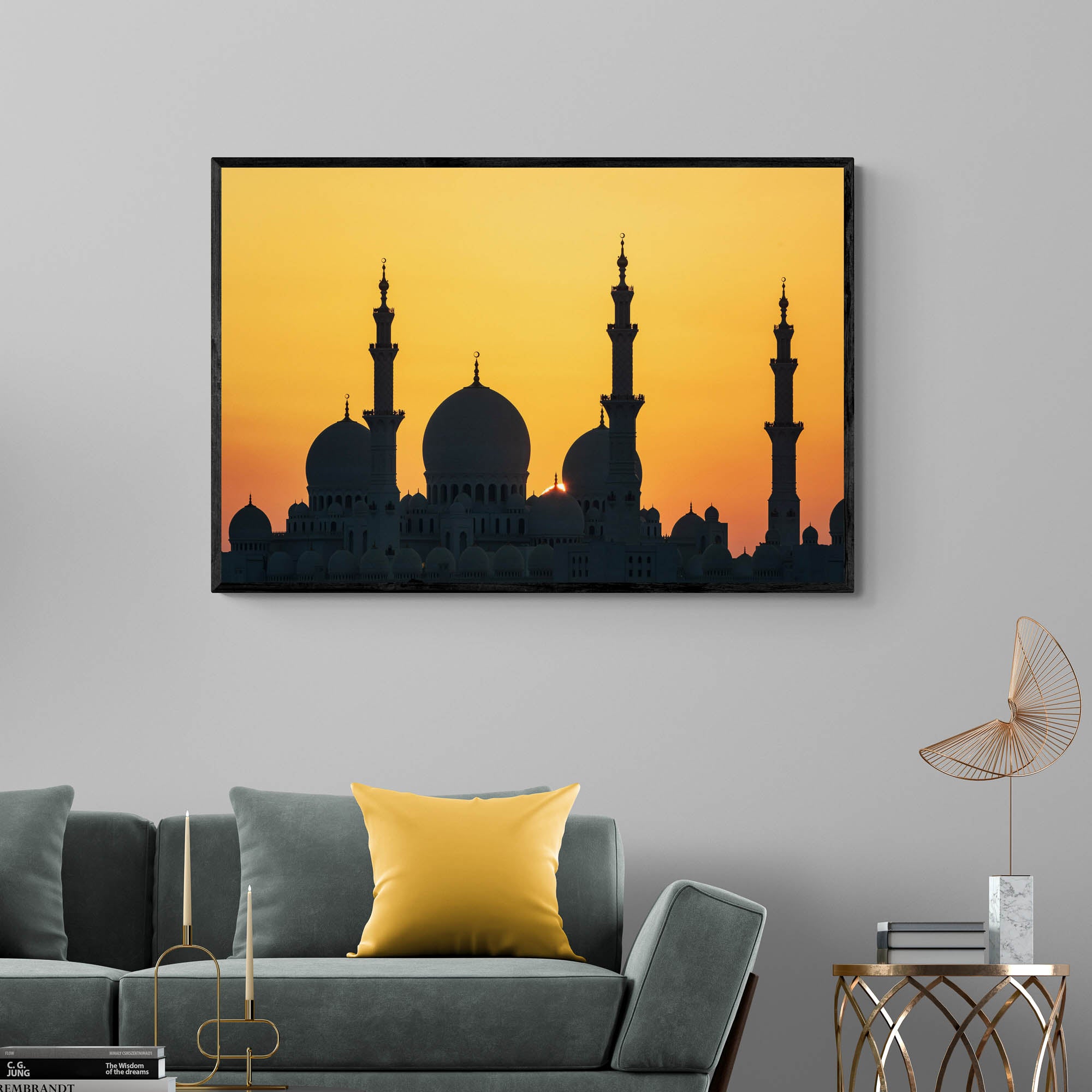 Silhouette of a grand mosque with multiple domes and minarets against a bright orange sunset sky in Abu Dhabi.