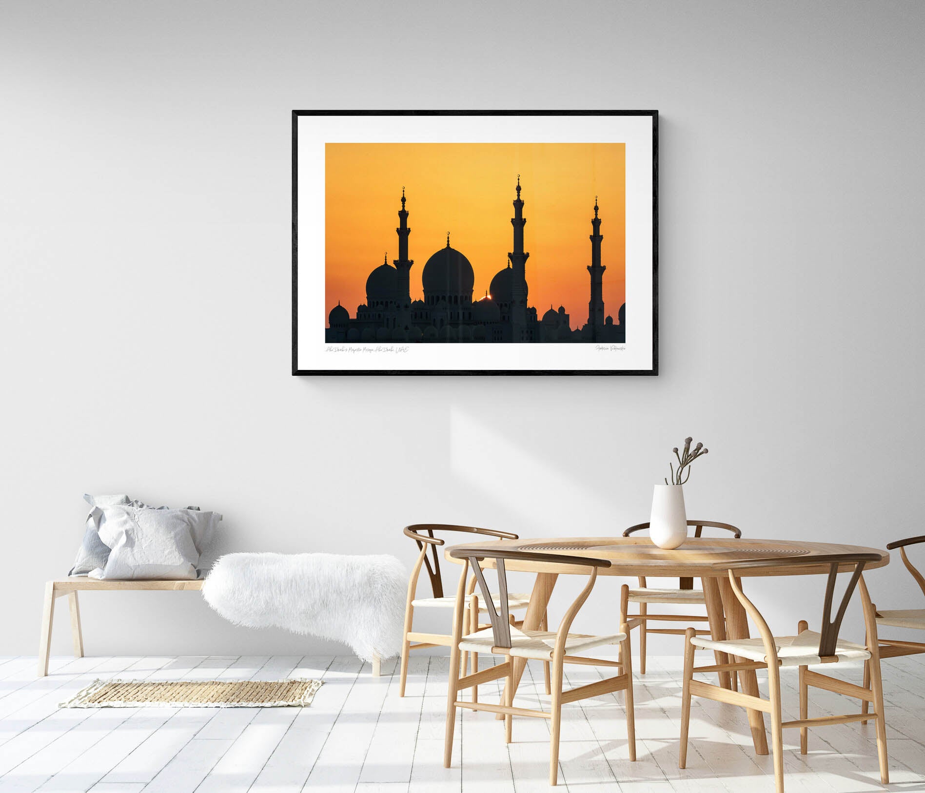 Silhouette of a grand mosque with multiple domes and minarets against a bright orange sunset sky in Abu Dhabi.