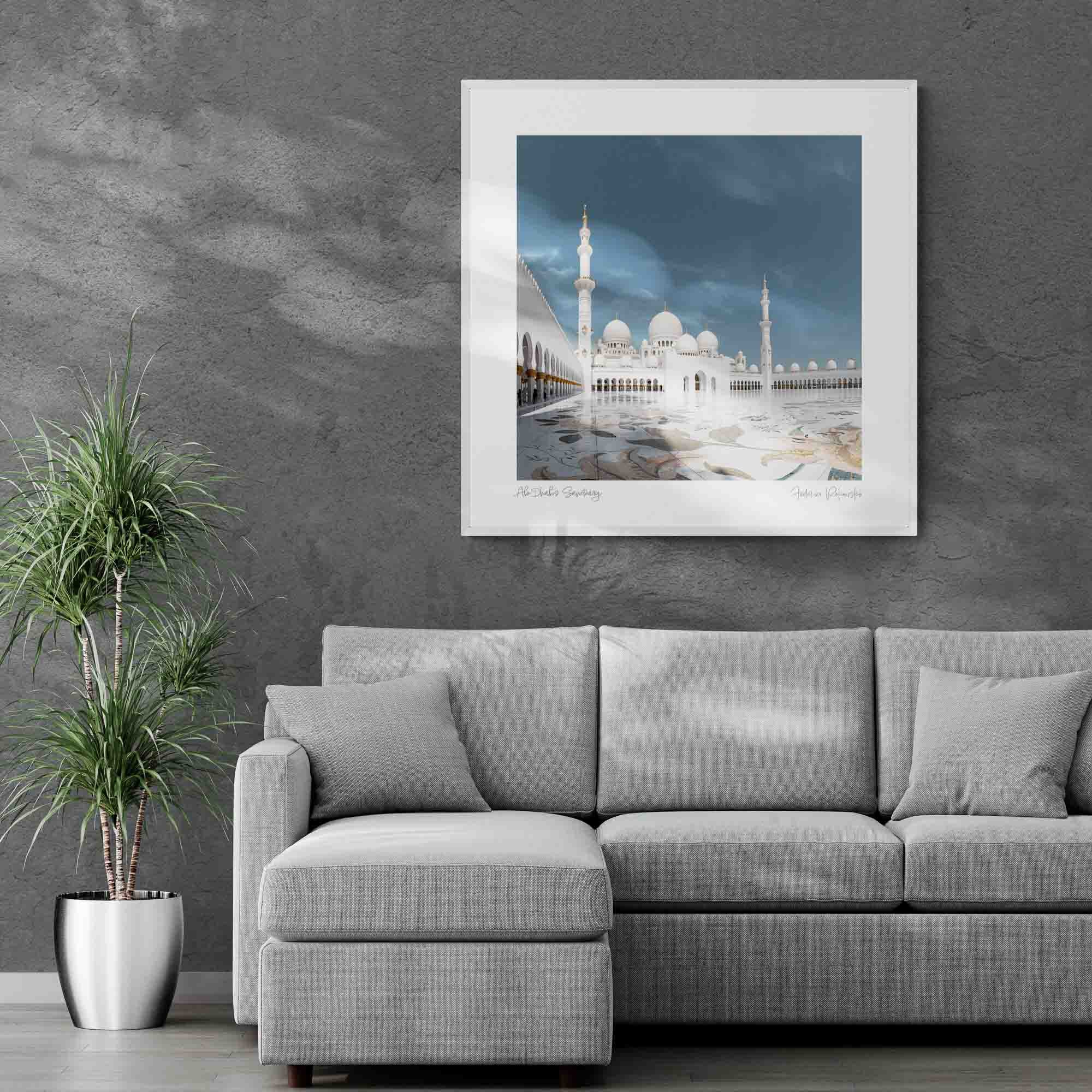 The Sheikh Zayed Grand Mosque in Abu Dhabi with its white marble domes and minarets, reflected on the glossy courtyard surface under a clear blue sky.