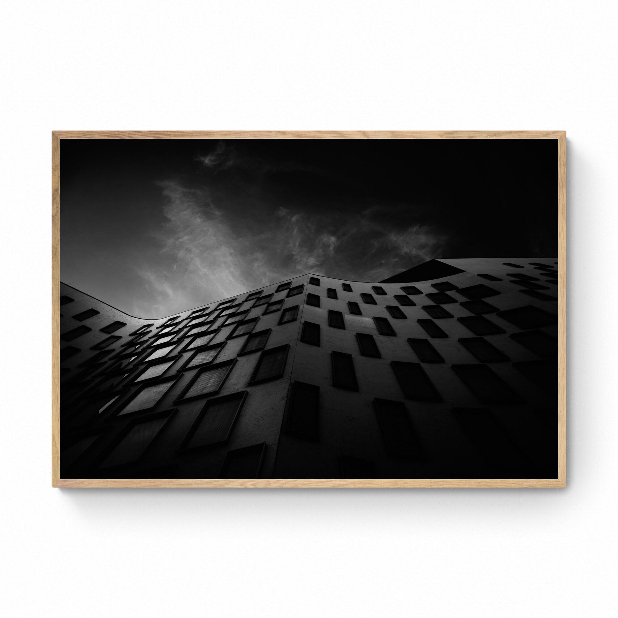 Silhouetted against the sky, the curved facade of the Vicki Sara Building at UTS, adorned with a pattern of dark windows.