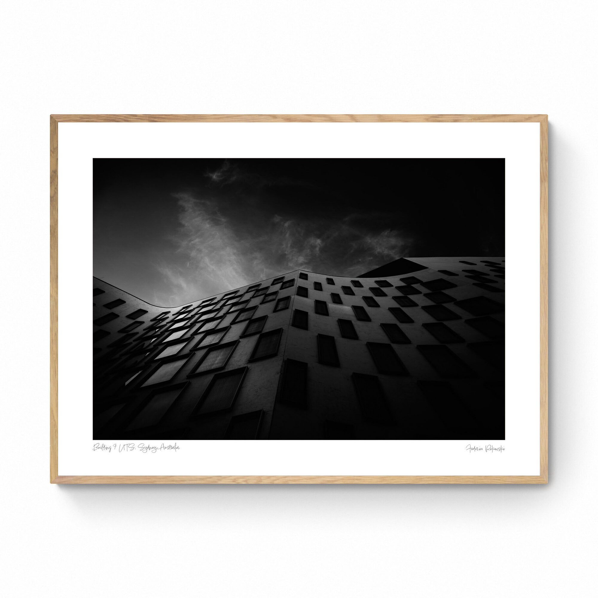 Silhouetted against the sky, the curved facade of the Vicki Sara Building at UTS, adorned with a pattern of dark windows.