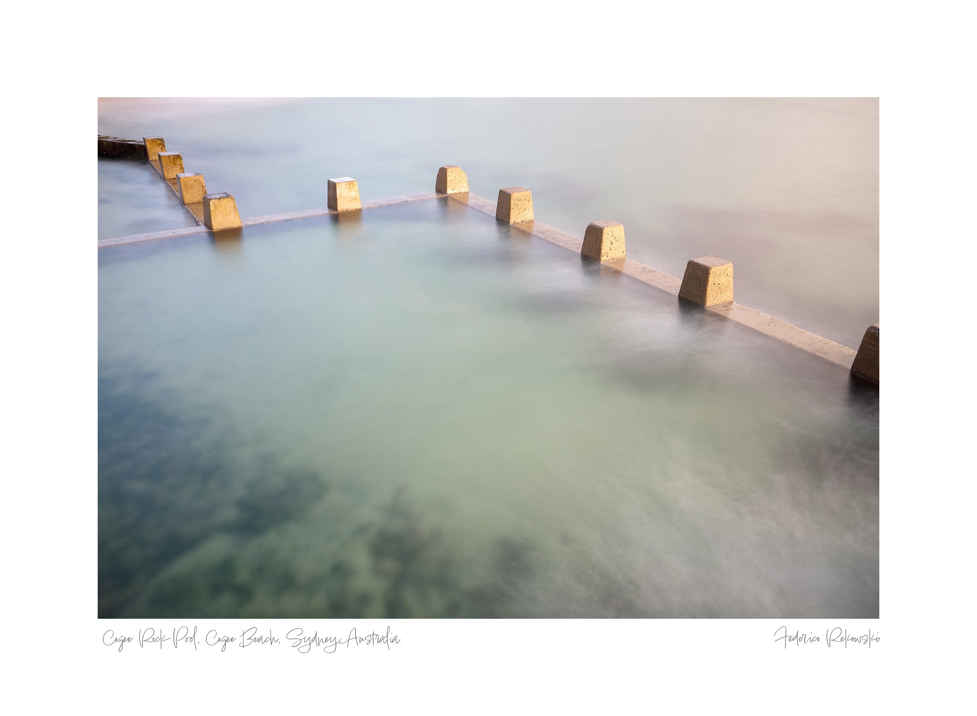 Long exposure photo of smooth, milky waters flowing around square concrete blocks in the ocean pool at Coogee Beach, Sydney, with subtle underwater details visible.