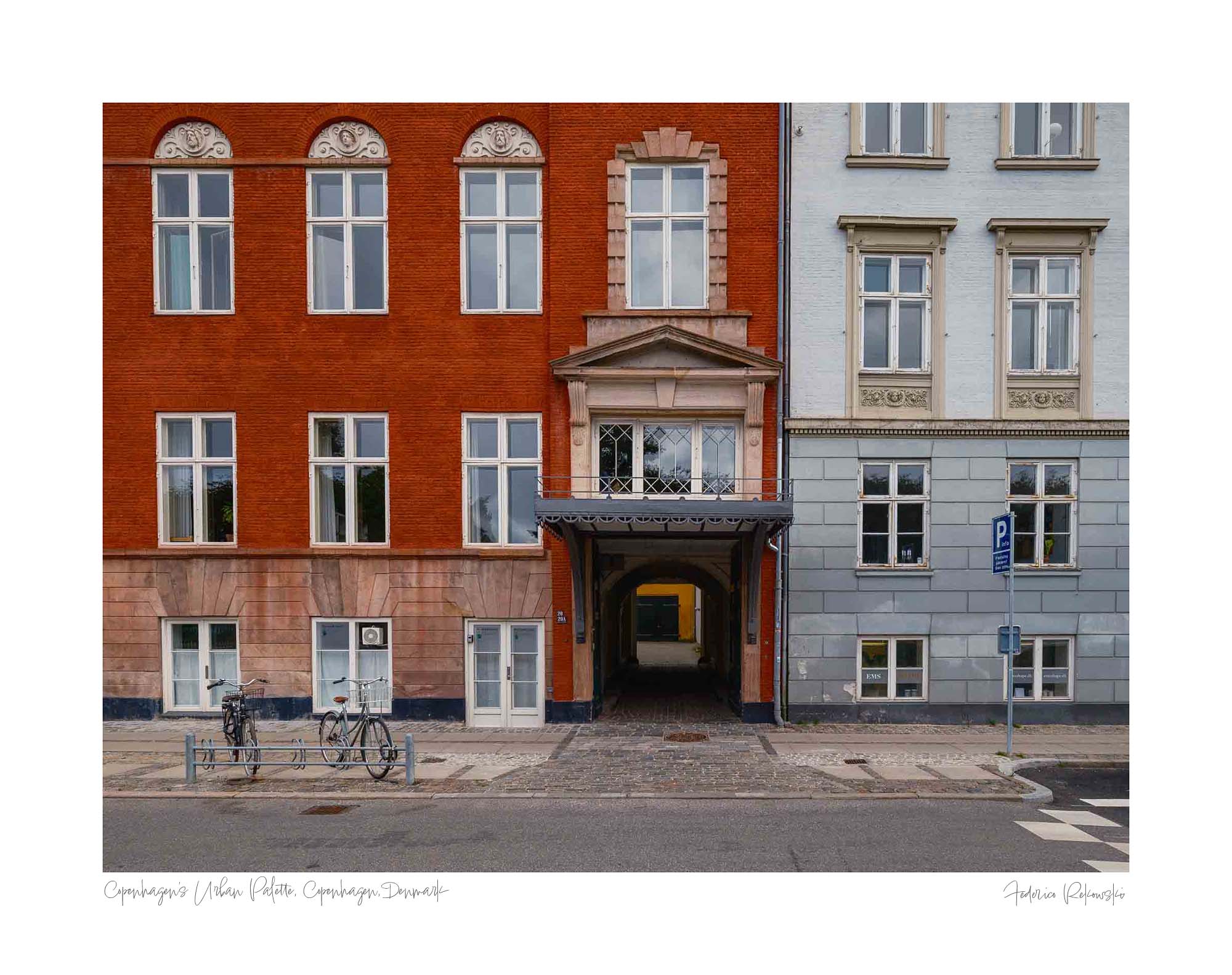 Colorful buildings in Copenhagen with a distinct red facade adjacent to a blue one, featuring a central archway leading to a hidden courtyard.