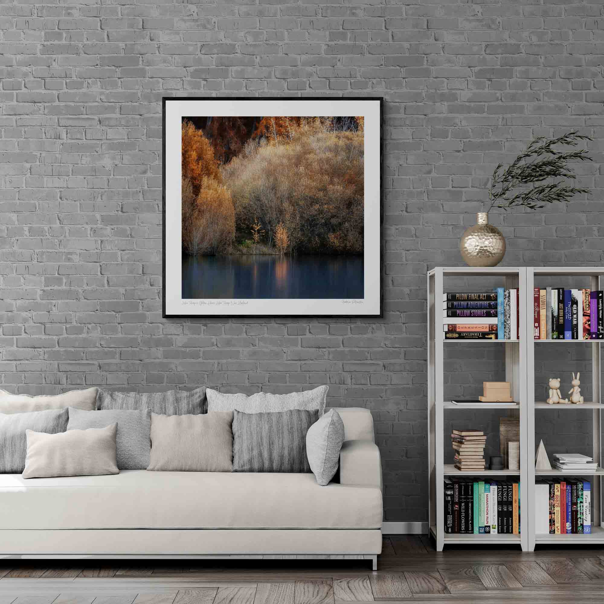 Golden autumn foliage by the peaceful shores of Lake Tekapo, New Zealand, with reflections in the calm water.