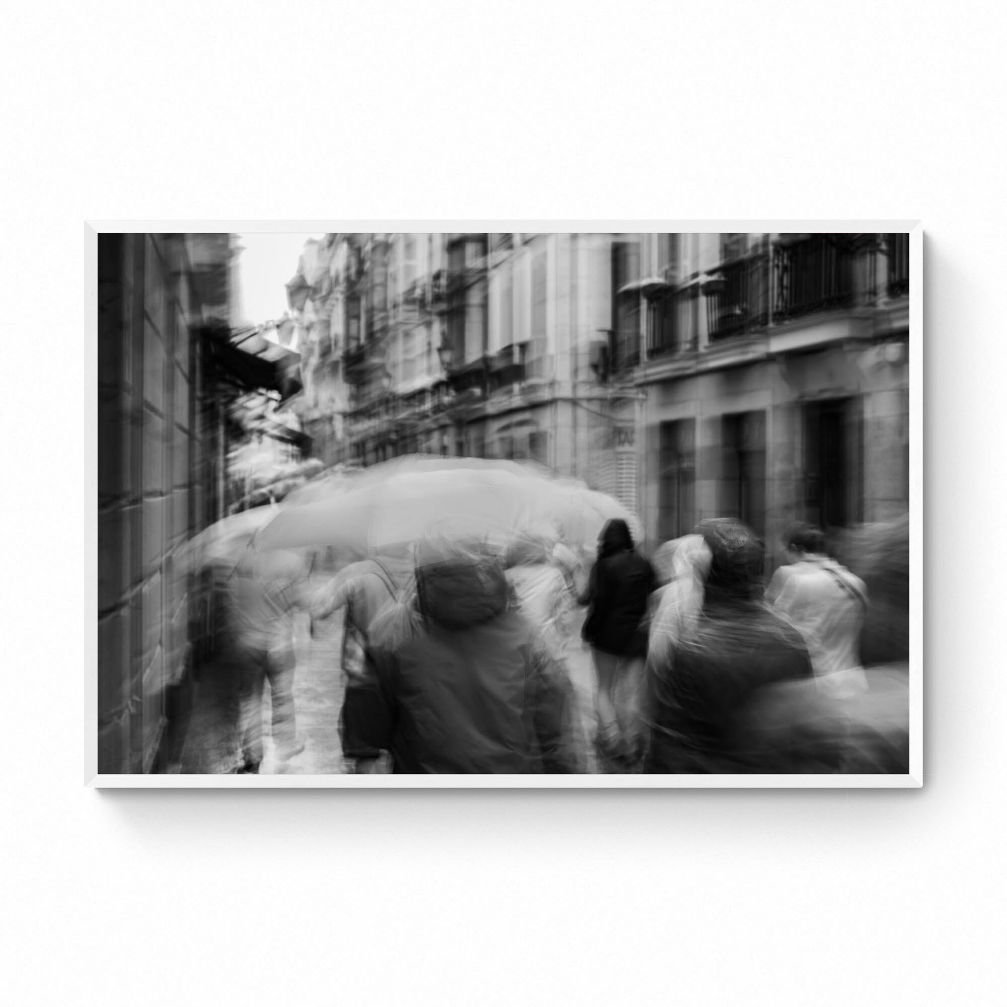 A monochrome image of pedestrians with umbrellas blurred by motion, embodying rain's lullaby in San Sebastian, inspired by Langston Hughes’ poetry.