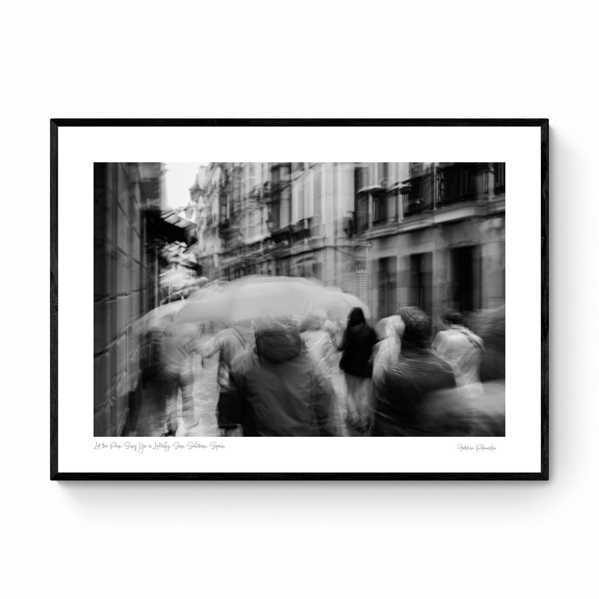 A monochrome image of pedestrians with umbrellas blurred by motion, embodying rain's lullaby in San Sebastian, inspired by Langston Hughes’ poetry.