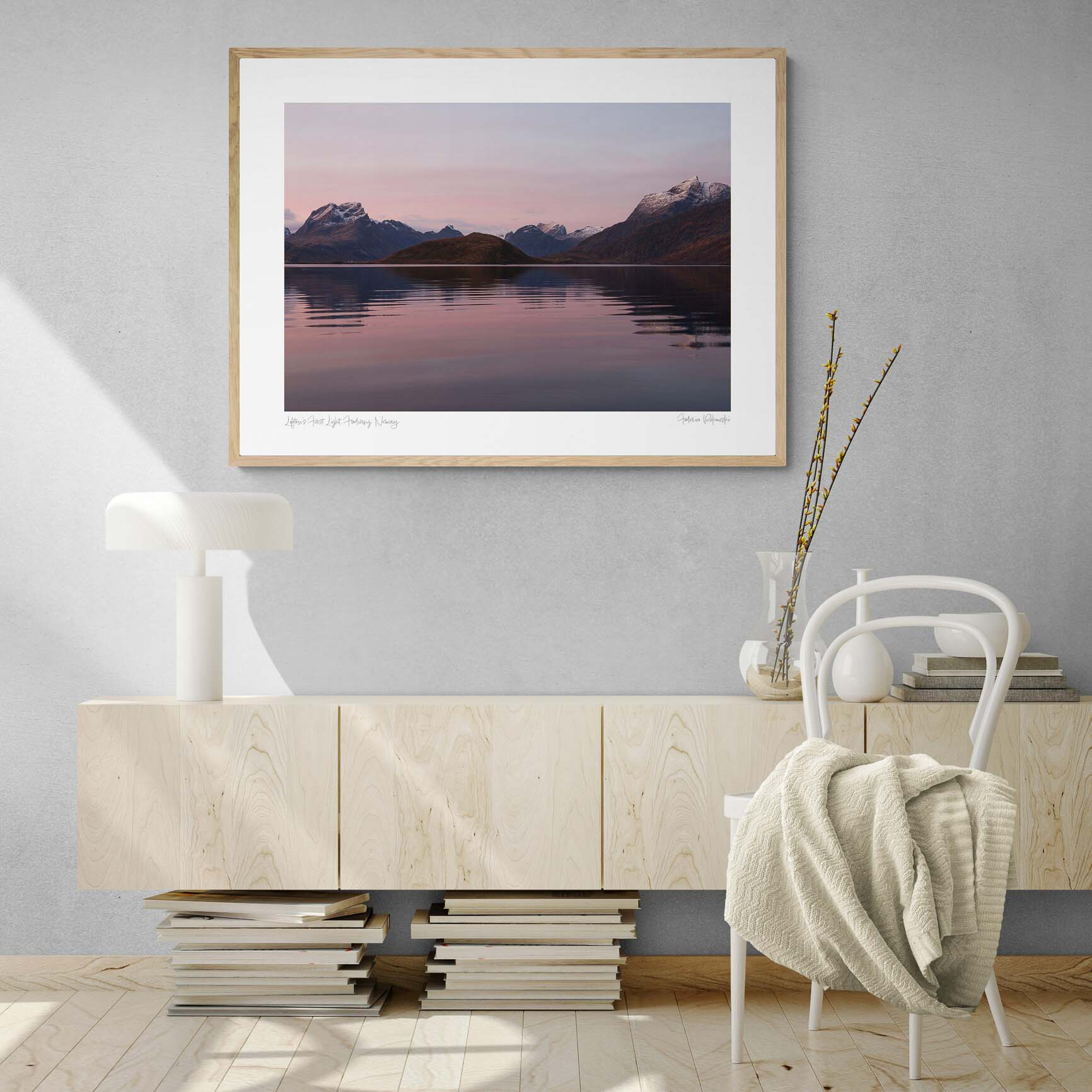 Sunrise at Fredvang in Lofoten, with snow-capped mountains reflecting in calm waters under a pastel-hued sky.