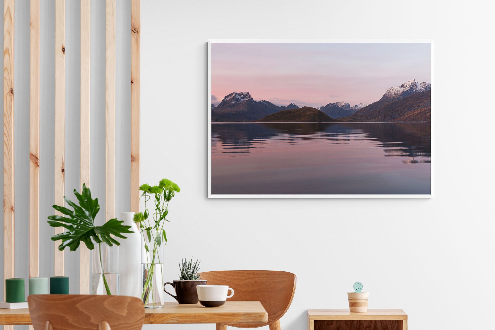 Sunrise at Fredvang in Lofoten, with snow-capped mountains reflecting in calm waters under a pastel-hued sky.