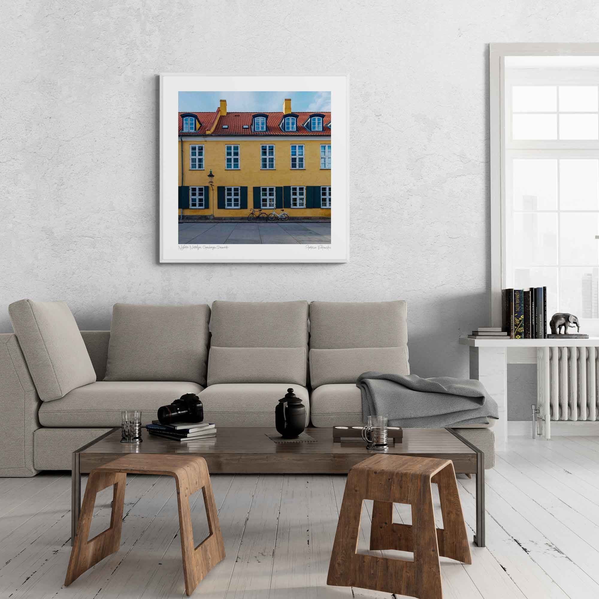 "Colorful image of a yellow building with green shutters and a bicycle in front on a street in Copenhagen, Denmark."