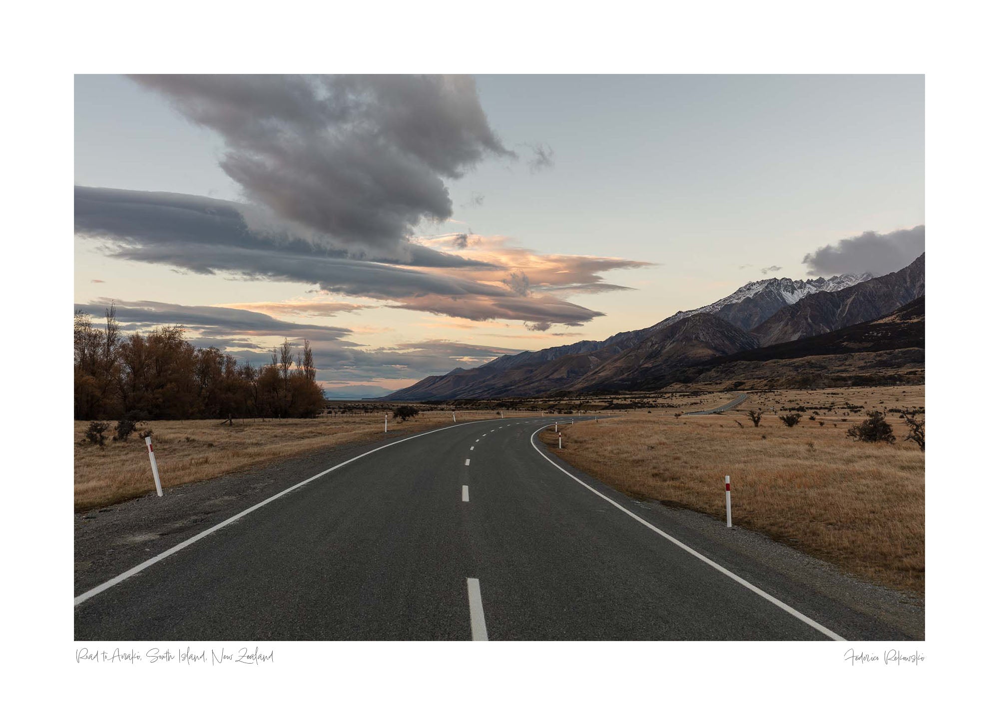 A serene landscape photograph of a road in New Zealand with Aoraki/Mt Cook in the background under a twilight sky with dynamic cloud formations.