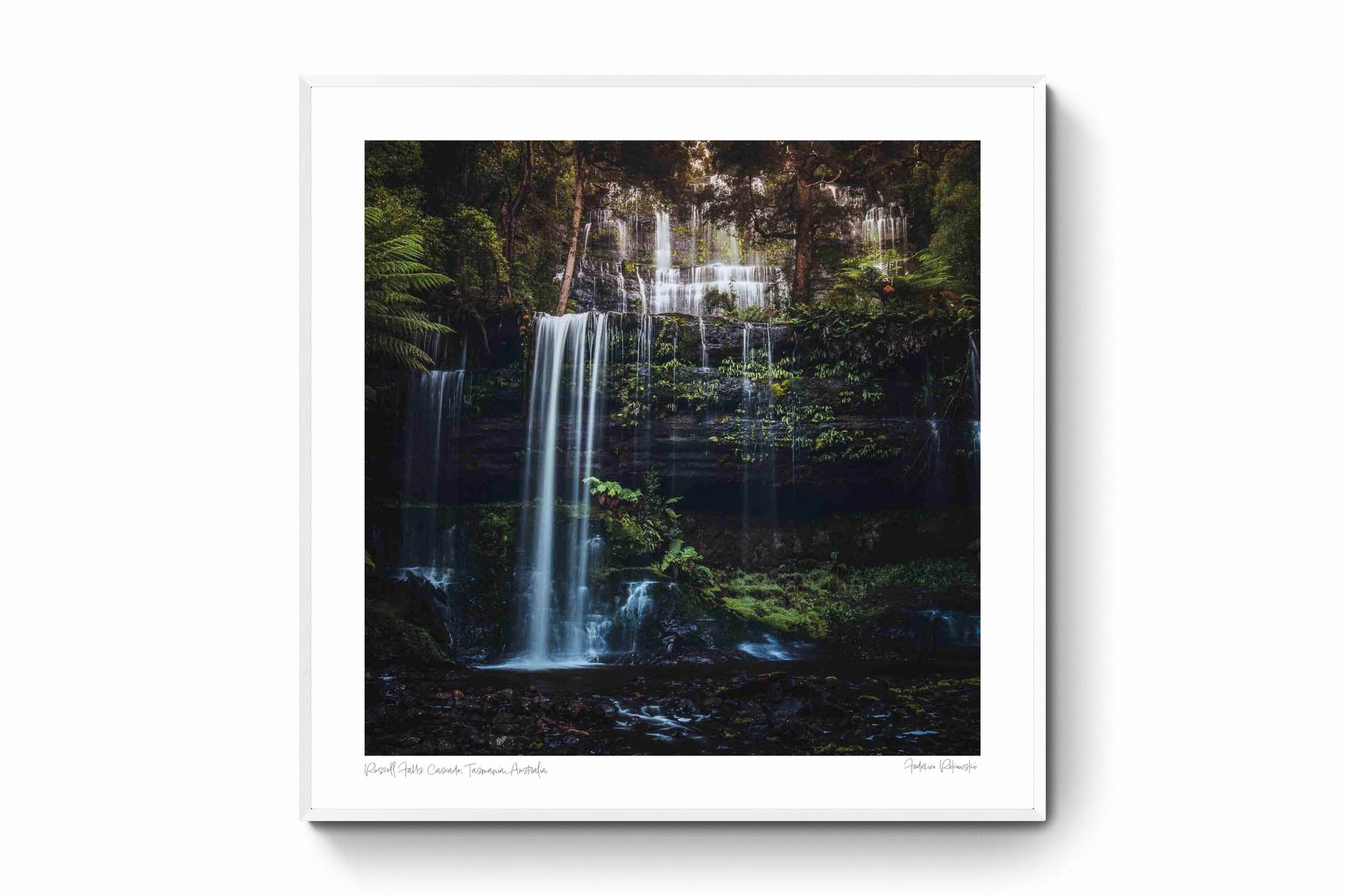 Long exposure photo of the multi-tiered Russell Falls in Tasmania, surrounded by a lush, fern-draped forest.