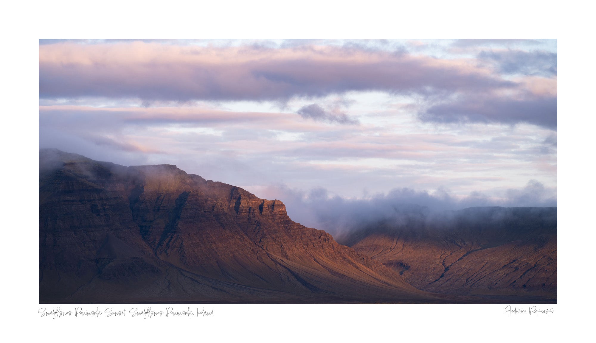 Late evening light bathes the Snæfellsnes Peninsula mountains in a warm glow with pink-tinged clouds above in Iceland.