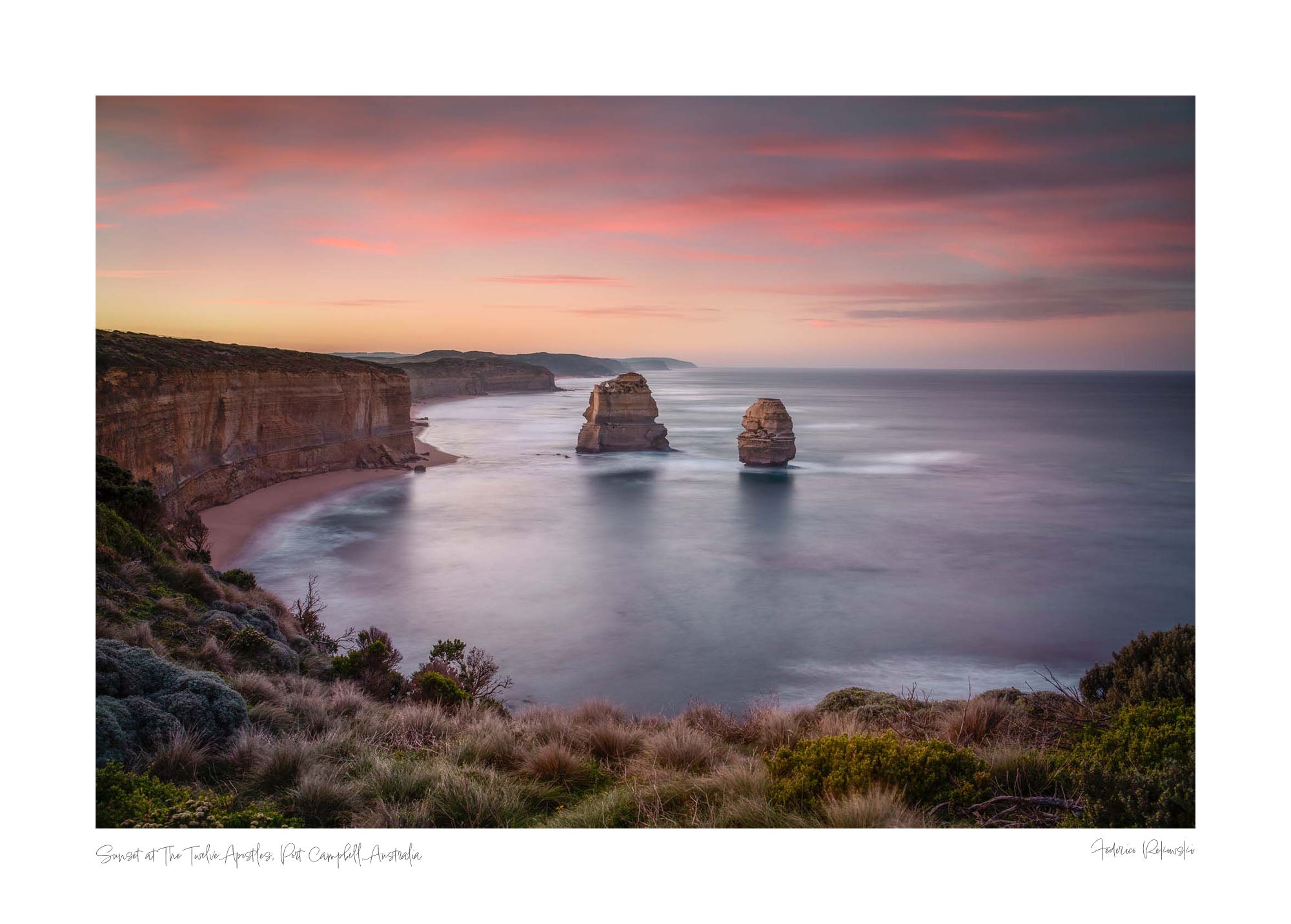 Sunset at The Twelve Apostles, with smooth seas and pastel skies highlighting the limestone formations off Australia's coast.