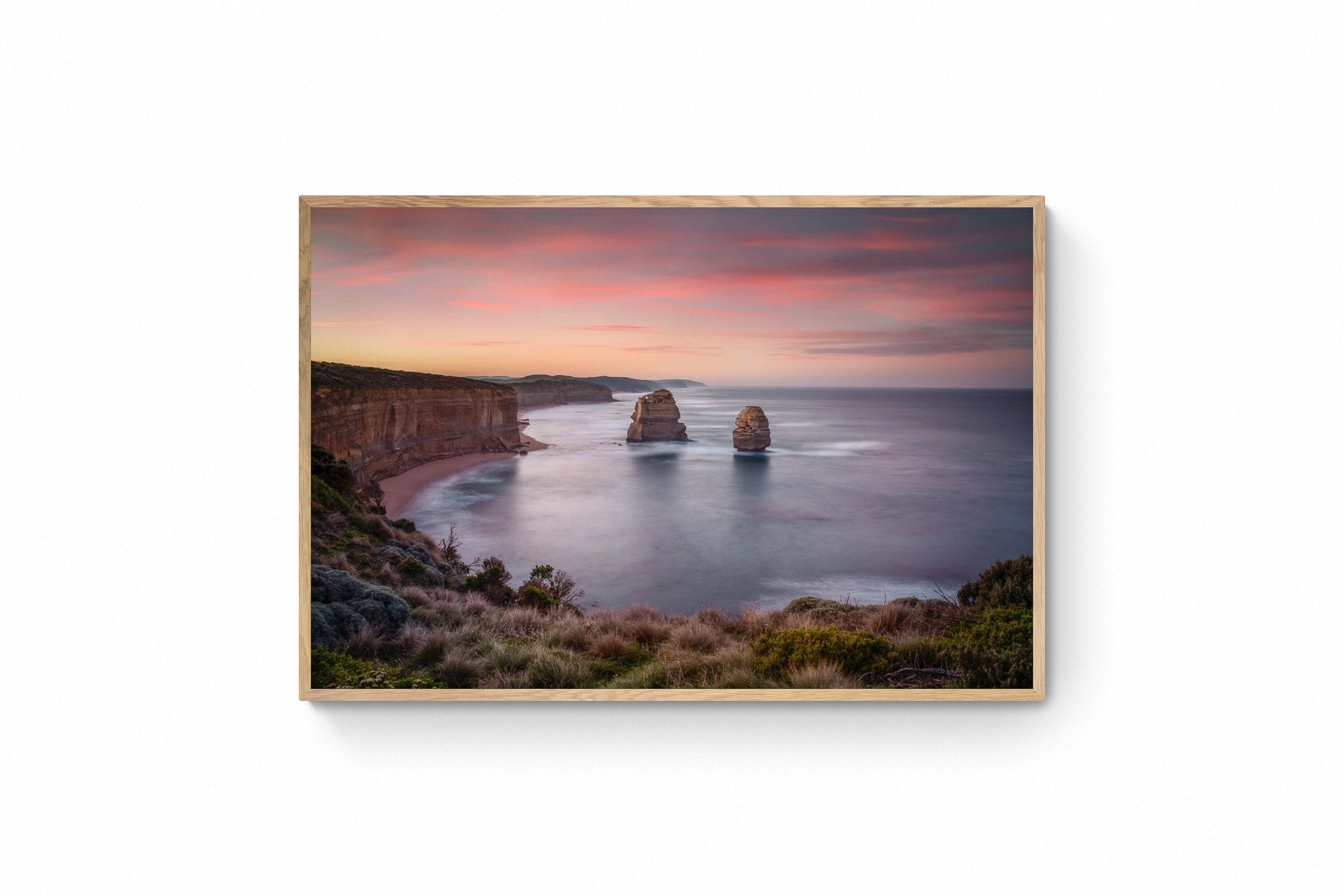 Sunset at The Twelve Apostles, with smooth seas and pastel skies highlighting the limestone formations off Australia's coast.