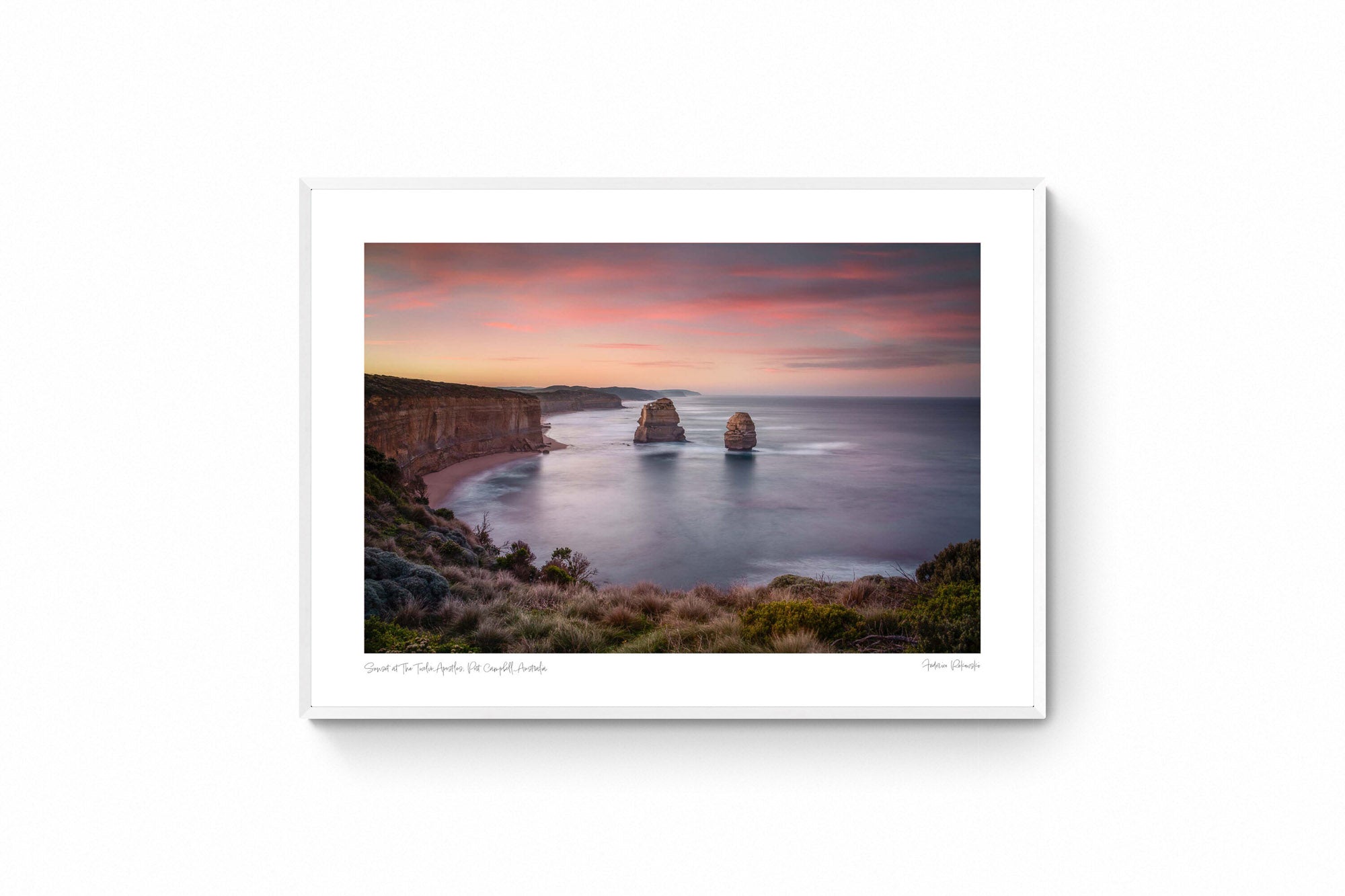 Sunset at The Twelve Apostles, with smooth seas and pastel skies highlighting the limestone formations off Australia's coast.