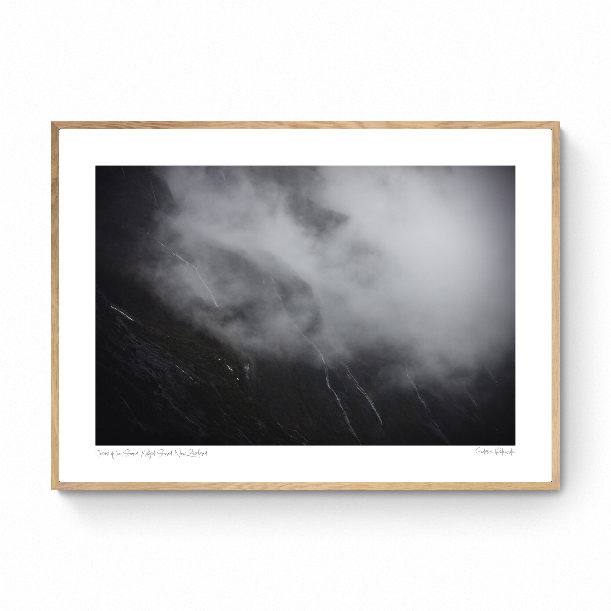 Photograph titled 'Tears of the Sound' showing misty waterfalls on the cliffs of Milford Sound, New Zealand, resembling tears against a somber backdrop.