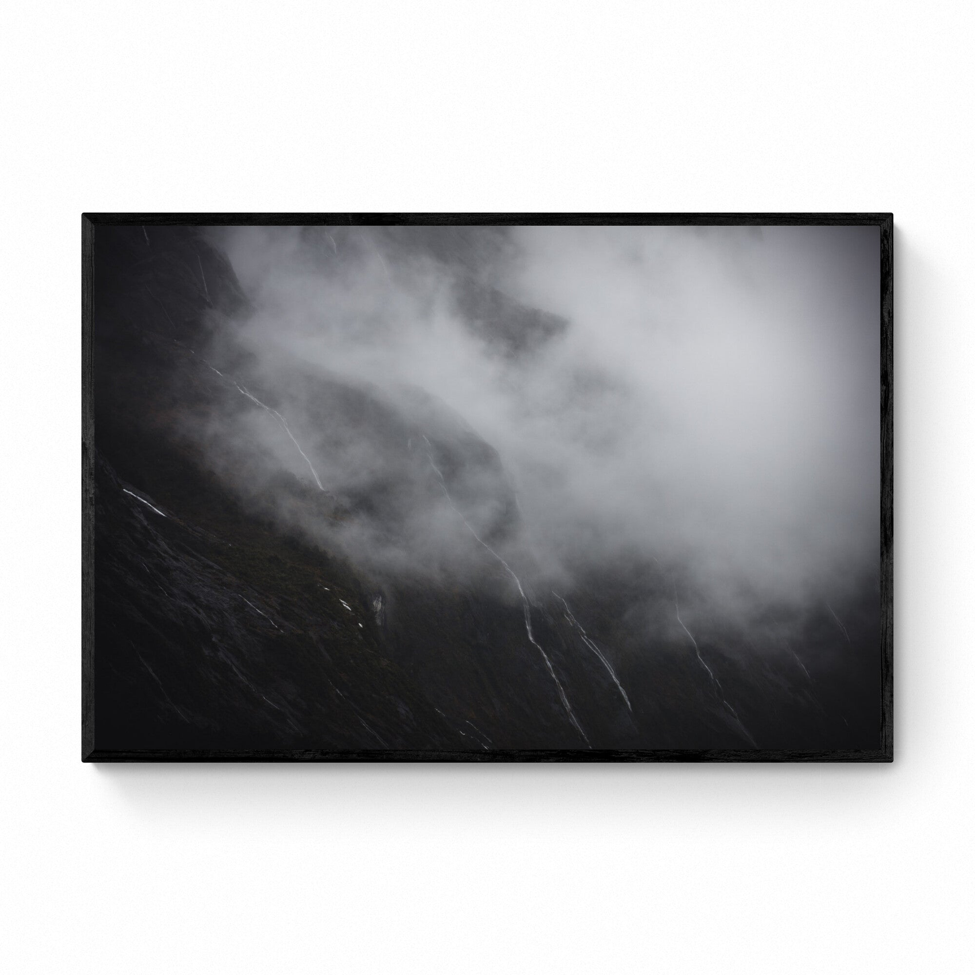 Photograph titled 'Tears of the Sound' showing misty waterfalls on the cliffs of Milford Sound, New Zealand, resembling tears against a somber backdrop.