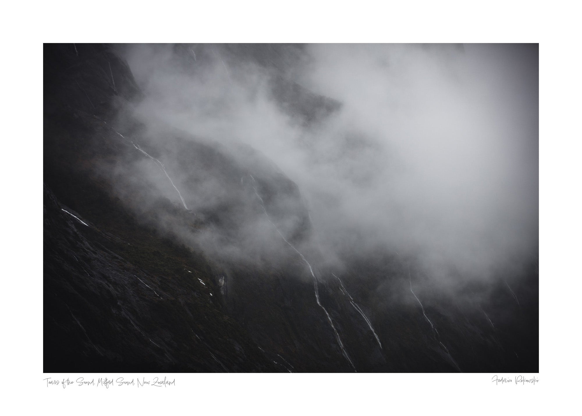 Photograph titled 'Tears of the Sound' showing misty waterfalls on the cliffs of Milford Sound, New Zealand, resembling tears against a somber backdrop.