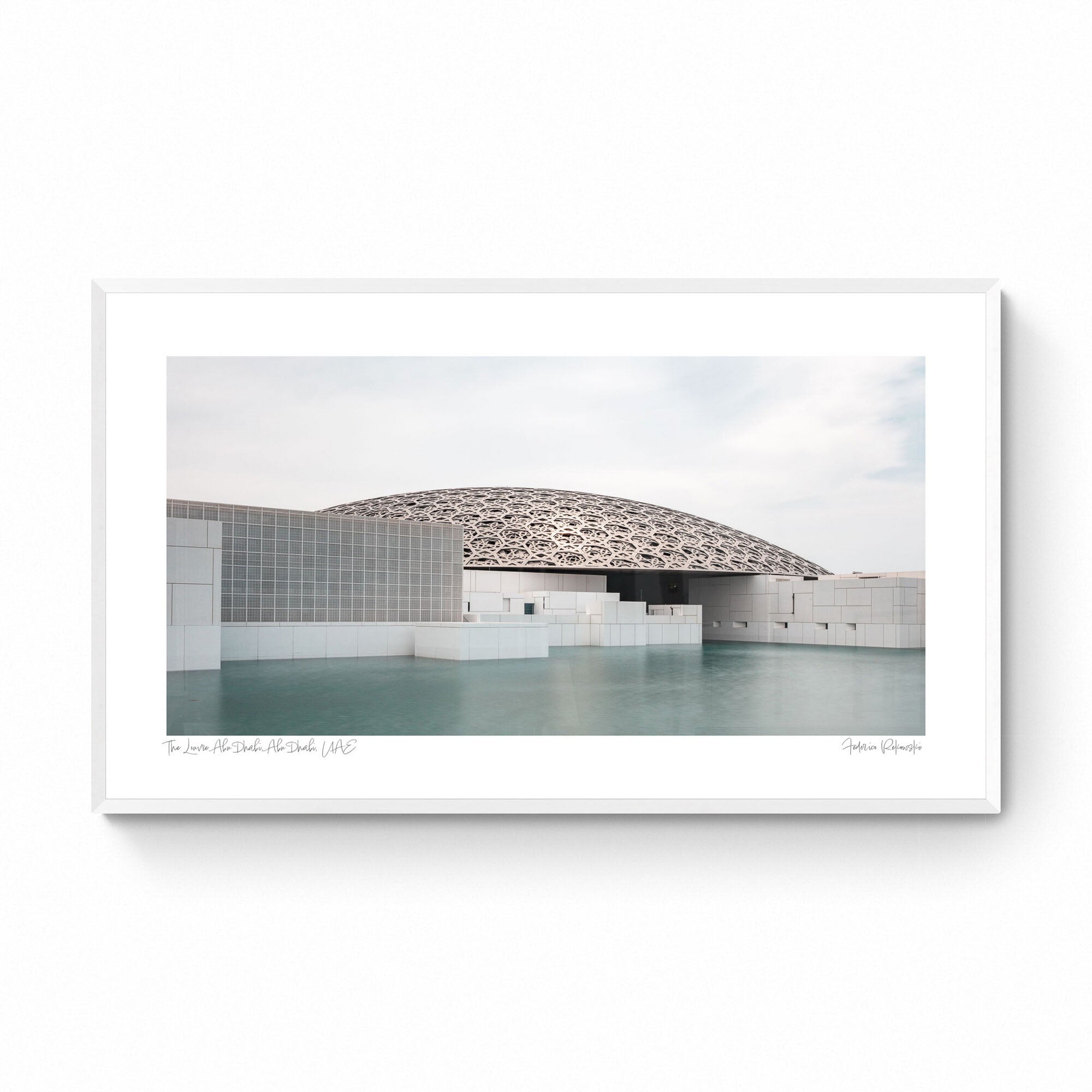 Wide-angle view of the Louvre Abu Dhabi’s intricate dome over calm water, under a soft sky.