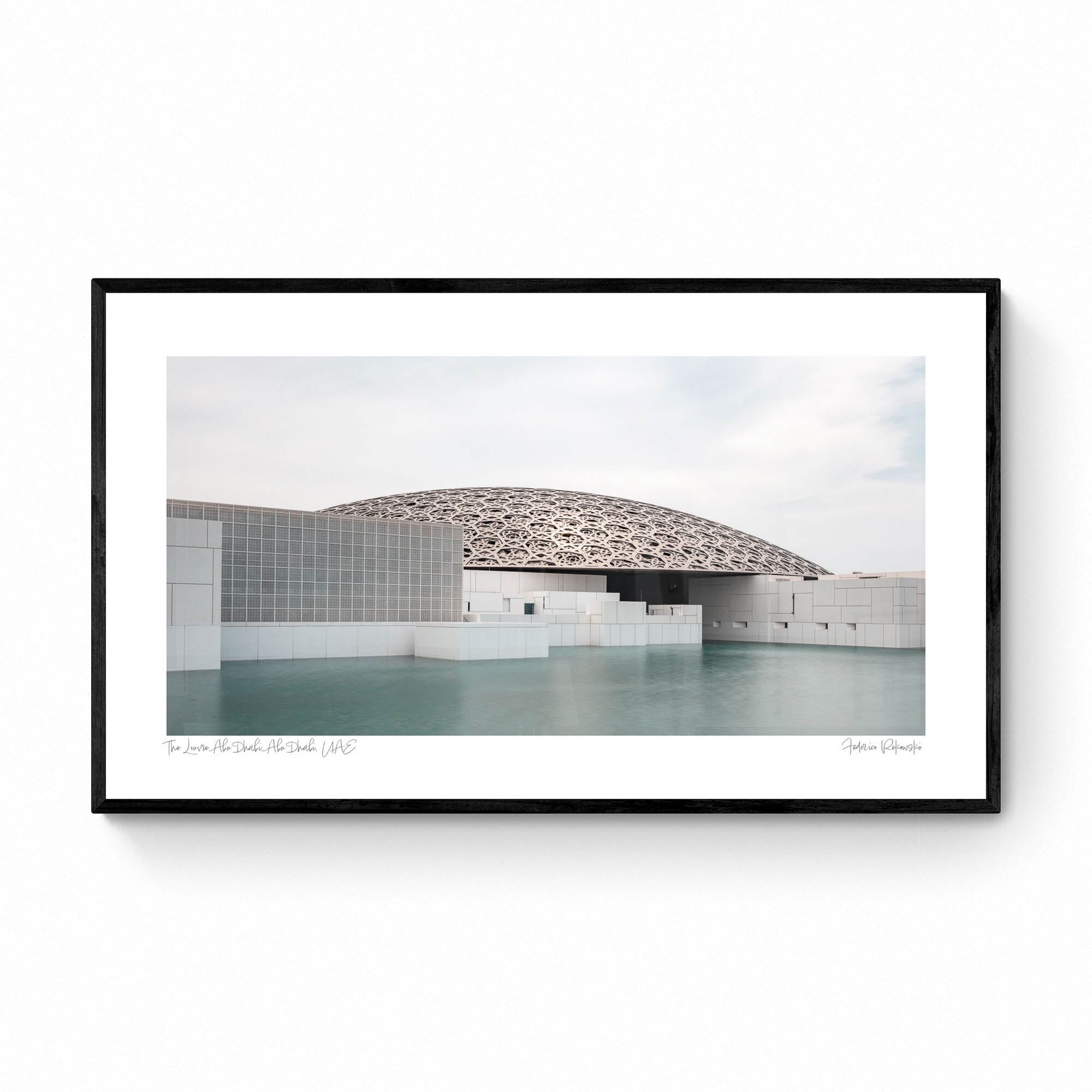 Wide-angle view of the Louvre Abu Dhabi’s intricate dome over calm water, under a soft sky.