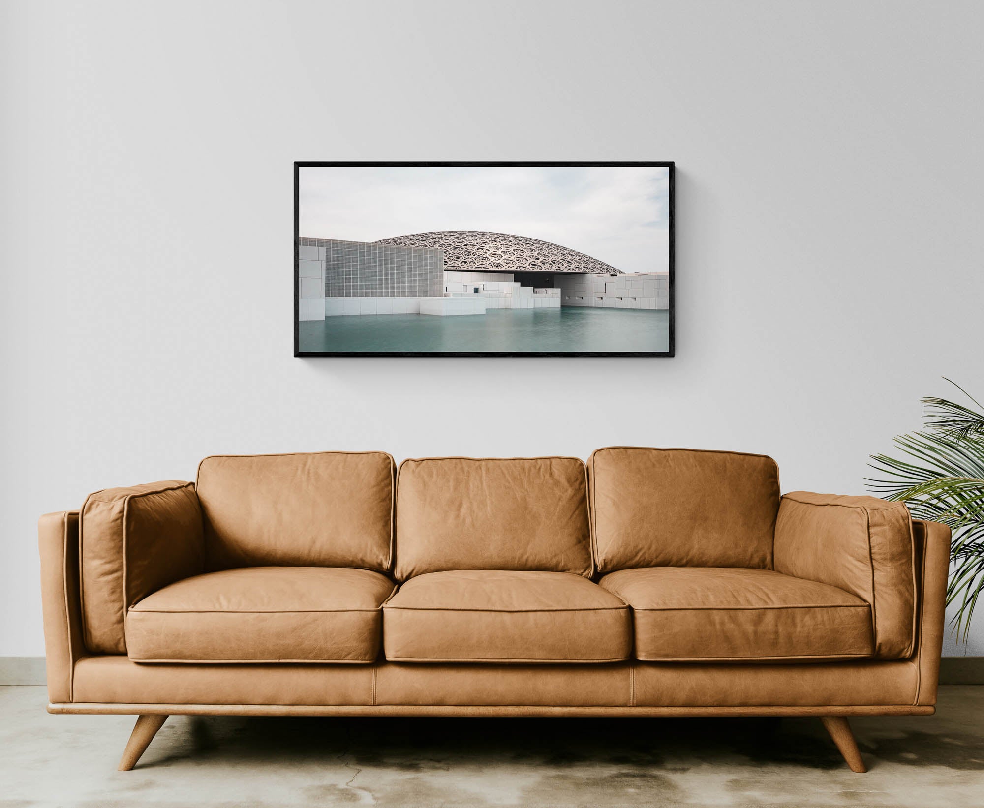 Wide-angle view of the Louvre Abu Dhabi’s intricate dome over calm water, under a soft sky.